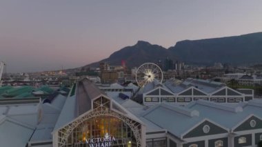 Victoria Wharf Alışveriş Merkezi 'nin üzerinde ilerliyoruz. Şehrin deniz kıyısında alacakaranlıkta. Cape Town, Güney Afrika.