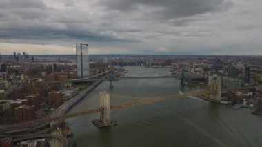 Doğu Nehri üzerindeki iki büyük yol köprüsünün havadan panoramik görüntüsü. Yağmurdan önce bulutlu gökyüzü altında şehir manzarası. Manhattan, New York City, ABD.