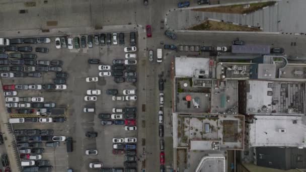 街区の通りや複数階建ての建物のパンニング映像のトップダウン 駐車場に車が立っている 米国ニューヨーク市マンハッタン — ストック動画