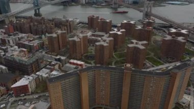 Konut arazisindeki binaların üzerinden uçuyor. Doğu nehri üzerindeki ünlü köprüleri ve diğer kıyılardaki kentsel yerleşim yerlerindeki binaları ortaya çıkarın. Manhattan, New York City, ABD.