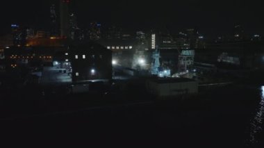 Rıhtımdaki rıhtımların üzerinde ilerleyin. Teknelerde parlayan ışıklar. Arka planda bir gece şehri. Manhattan, New York City, ABD.