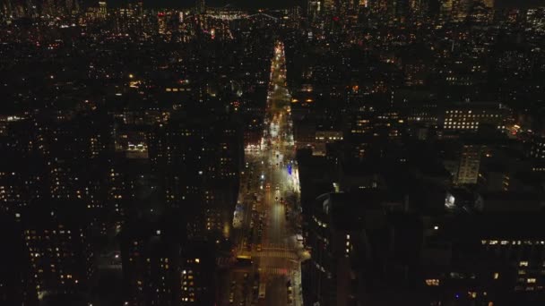 汽车夜间行驶在市区光芒四射的街道上 市中心的摩天大楼相距很远 纽约市 曼哈顿 — 图库视频影像