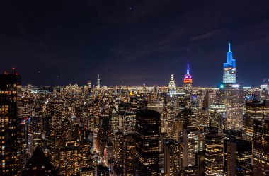 Chrysler, Empire State ve One Vanderbilt gibi ünlü gökdelenlerin tepesinde renkli çiviler var. İnanılmaz bir gece şehri sahnesi. Manhattan, New York City, ABD.