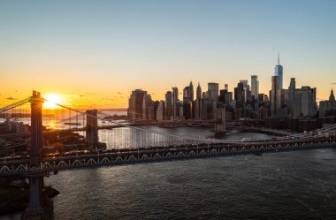 Günbatımında Aşağı Manhattan 'daki modern ofis kulelerinin hava panoramik görüntüsü. Doğu nehri üzerindeki köprülerin romantik akşam çekimleri. Manhattan, New York City, ABD.