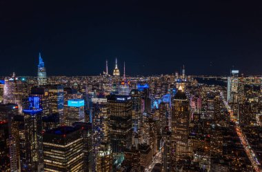 Gece Metropolis 'in hava panoramik görüntüsü. Şehir merkezindeki yüksek binaların renkli neon ışıkları. Manhattan, New York City, ABD.