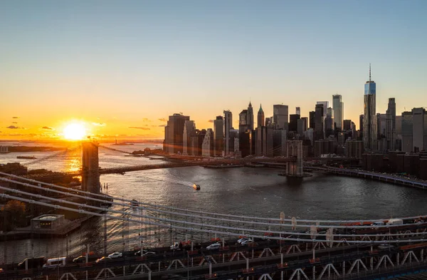 Manhattan ve Brooklyn Köprüleri altın günbatımına karşı. Modern gökdelenlerin hava manzaralı görüntüleri. Manhattan, New York City, ABD.