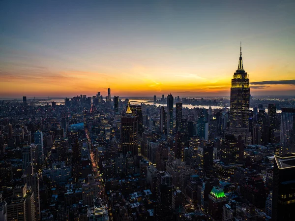 Sokaklarla çevrili bloklardaki yüksek binalar. Renkli günbatımı gökyüzüne karşı şehir manzarası. Manhattan, New York City, ABD.