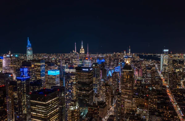 Gece Metropolis 'in hava panoramik görüntüsü. Şehir merkezindeki yüksek binaların renkli neon ışıkları. Manhattan, New York City, ABD.