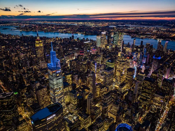 Evening city panorama. Illuminated high rise buildings in city centre and colour twilight sky in background. Manhattan, New York City, USA.