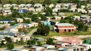 İşçi kolonisindeki küçük evlerin kamera görüntülerini kaydır. Banliyölerdeki benzer alçak binalar grubu. Güney Afrika.