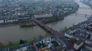 Şehrin içinden akan geniş nehrin hava panoramik görüntüleri. Eski yol köprüsündeki trafiğin kayma ve yan görüntüsü. Rıhtımdaki kilise. Frankfurt am Main, Almanya.