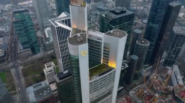 Commerzbank Kulesi 'nin üst kısmının görüntüsünü geri çek. Yukarı doğru eğil şehir merkezindeki gökdelenleri ve şehir manzarasının puslu görüntüsünü ortaya çıkar. Frankfurt am Main, Almanya.