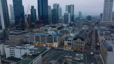 Alacakaranlıkta şehir merkezindeki çok katlı binaların görüntülerini indirin. Dükkanları olan sokaklar ve yaya bölgeleri. Arka planda modern gökdelenler. Frankfurt am Main, Almanya.