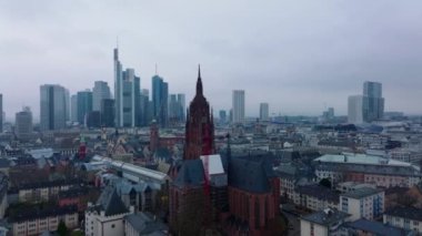 Frankfurter Dom kulesinin çevresindeki binaların üzerinden uçuyor. Arka planda iş merkezindeki modern ofis kuleleri. Frankfurt am Main, Almanya.