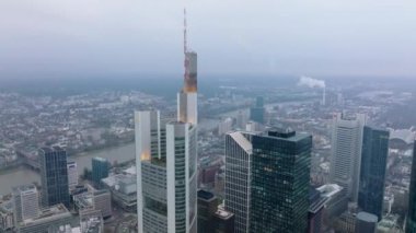 Şehir merkezindeki gökdelenlerin yüksek görüntüsü. Modern ofis kulesinin tepesine uç. Arka planda nehir olan bir şehir. Frankfurt am Main, Almanya.