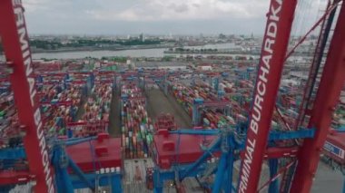 Fly between majestic gantry cranes, revealing thousands of overseas containers in logistic cargo terminal. Intermodal transport and global logistics. Hamburg, Germany.
