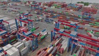 High angle view of work in transport terminal. Cranes in harbour moving with containers from various vehicles. Intermodal transport and global logistics. Hamburg, Germany.