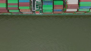 Fly over majestic container cargo boat in harbour. Top down shot. Intermodal transport and global logistics. Hamburg, Germany.