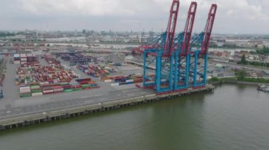 Aerial view of transport terminals around Elbe river in industrial and logistic neighbourhood. Large gantry cranes in harbour. Intermodal transport and global logistics. Hamburg, Germany.