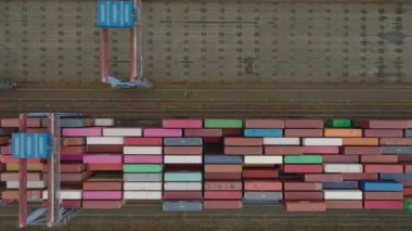 Top down footage of large logistic terminal in harbour. Stacked naval containers and large portal cranes on rails. Intermodal transport and global logistics. Hamburg, Germany.