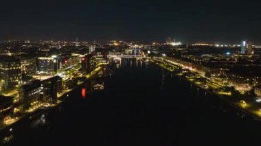 Night aerial hyperlapse shot of illuminated city. Forwards fly above water canal in central city. Copenhagen, Denmark.