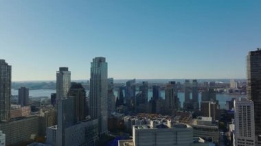 Nehir kıyısındaki yüksek binaların havadan yükselen görüntüsü. Güneşli bir gün ve açık bir gökyüzü. Manhattan, New York City, ABD.