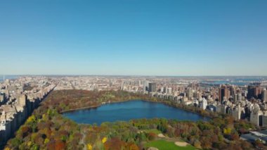 Jacqueline Kennedy Onassis Barajı 'nın sonbahar ağaçlarıyla çevrili olduğu şehir ve Central Park' ın panoramik manzarası. Manhattan, New York City, ABD.