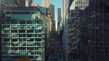 Şehir merkezine doğru uzun düz bir caddenin üzerinden uç. Birçok penceresi olan çeşitli ofis ya da ticari binalar. Manhattan, New York City, ABD.
