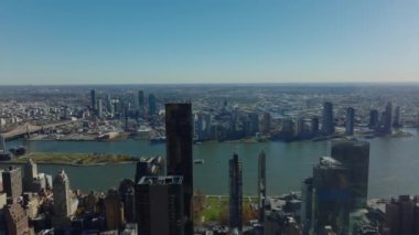 East River rıhtımındaki yüksek binaların ve karşı kıyıdaki Queens bölgesinin havadan panoramik görüntüsü. Güneşli bir günde gökyüzü açık. Manhattan, New York City, ABD.