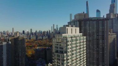 Yüksek binaların etrafında yükseltilmiş uçuş. Renkli sonbahar parkı ve yüksek gökdelenleri gözler önüne seriyor. Manhattan, New York City, ABD.