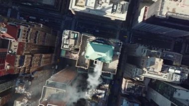 Gökyüzü kuşları, şehrin tarihi yapılarının çatısında baca dumanı içerken yukarıdan aşağıya doğru yükseliyor. Manhattan, New York City, ABD.