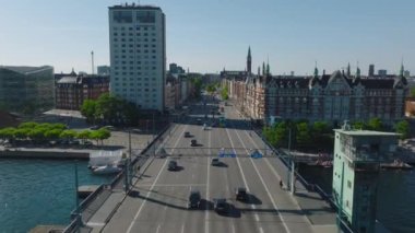 İleri, köprünün üzerinden su üzerinde uçar. Şehir merkezindeki trafiği takip ediyoruz. Taraflı tarihi çok katlı binalar. Kopenhag, Danimarka.