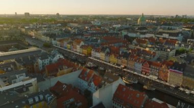 Nyhavn boyunca parlak renkli evler. Gezinti güvertesi ve eski yelkenlileri olan turistik bir yer. Gün batımında havadan panoramik görüntü. Kopenhag, Danimarka.
