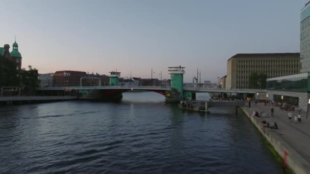 水面上の低い飛行 Knippels Bridgeを飛び越え 夕暮れ時にウォーターフロントの建物を明らかにします デンマークのコペンハーゲン — ストック動画