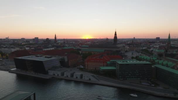 黄昏时城市的空中全景镜头 沿著运河的现代设计建筑和历史地标塔的轮廓 丹麦哥本哈根 — 图库视频影像