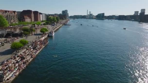 阳光明媚的日子 朝前飞去 飞越城市的水渠 闪闪发光的水面反射着阳光 人们在海滨放松 丹麦哥本哈根 — 图库视频影像