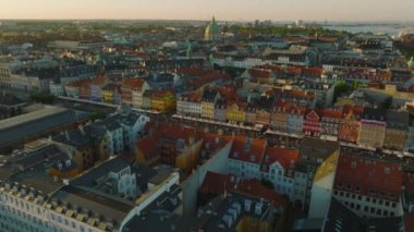 Altın saatinde şehir merkezindeki tarihi binaların üzerinden uç. Eski rıhtımlardaki renkli yüzler Nyhavn. Kopenhag, Danimarka.