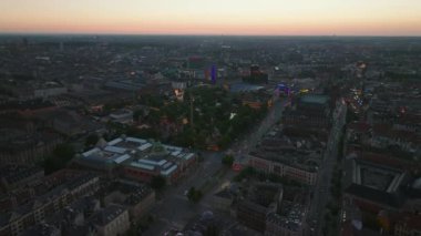 Alacakaranlıkta şehir manzarası. Şehir merkezinin üzerinde Tivoli bahçe eğlence parkı, Sanat Müzesi ve belediye binası boyunca uzanan işlek çoklu yol ile uçun. Kopenhag, Danimarka.