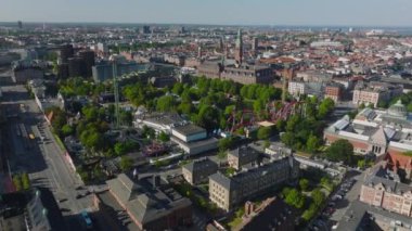 Hava manzaralı Tivoli Bahçeleri eğlence parkı. Şehir merkezindeki büyük lunapark trenleri ve diğer eğlence merkezleri. Arka planda uzun kulesi olan belediye binası. Kopenhag, Danimarka.