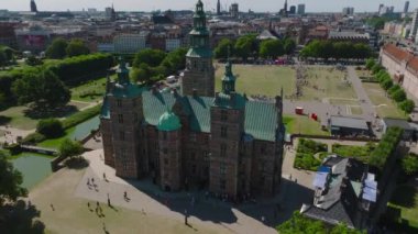 Rosenborg kalesinin üzerinden uç. İnsanların parkta spor müsabakalarını izlemesi. Şehrin arka planında binalar var. Kopenhag, Danimarka.