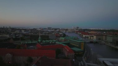 Meşhur Borsen ve çevredeki diğer tarihi binalar. Akşam kentinde su kanalında yelken açan teknelerin görüntüsü. Kopenhag, Danimarka.