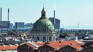 Frederiks Kirke 'ün güzel büyük kubbesi yakınlaştırılmış arka planda. Deniz kıyısındaki elektrik santrali ve rüzgar çiftliği. Kopenhag, Danimarka.