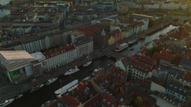 Nyhavn 'ın yüksek açılı manzarası, su kanalı ve demirli tekneleri olan turist caddesi. Gün batımında şehir manzarasını göster. Kopenhag, Danimarka.