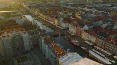 Nyhavn 'ın günbatımındaki inanılmaz görüntüsü. Turistik bir manzara. Rıhtımdaki su kanalı boyunca renkli evler korunmuş. Kopenhag, Danimarka.