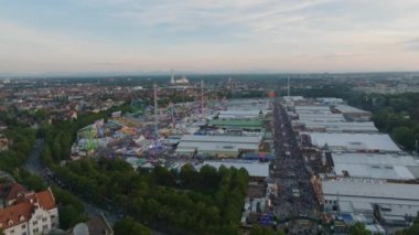 Turistler ve yerliler dünyaca ünlü eğlence fuarı ve bira festivalinin tadını çıkarıyorlar. Alacakaranlık 'taki Oktoberfest bölgesinde büyük çadırlar ve lunapark. Münih, Almanya.