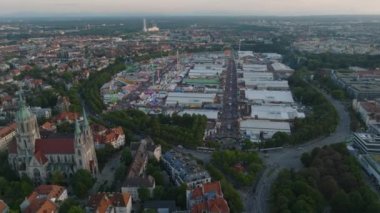 Theresienwiese 'deki Ekim Festivali, ünlü bira ve Bavyera' daki halk festivali manzarası. Geriye dönük olarak büyük kilise ve konut binaları görünüyor. Münih, Almanya.