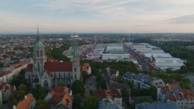 Alacakaranlıkta şehrin üzerinde uç. St. Pauls kilisesinin ve Theresienwiese 'deki Ekim Festivali' nin kaydırak ve pan görüntüleri. Ünlü ve iyi katılan bira festivali. Münih, Almanya.