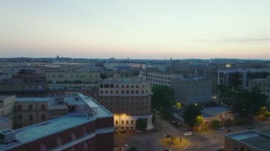 Alacakaranlıkta şehirde binalar ve sokaklar. Apartman blokları ve şehir merkezinde aydınlatılmış döner kavşak. Roma, İtalya.