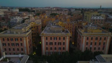 Renkli binaların olduğu çok katlı apartmanların havadan yükselen görüntüleri. Alacakaranlık 'taki yerleşim yeri. Roma, İtalya.