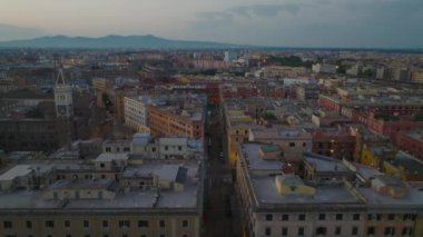 Şehir merkezindeki çok katlı evler ve sokaklar. İleriye doğru alacakaranlıkta şehrin üzerinde uçar. Roma, İtalya.